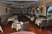 Un comedor con mesas y sillas con manteles blancos. en The Royal Retreat, en Ranchi