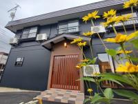 una casa azul con una puerta de madera y flores amarillas en 草津温泉お宿きみのや, en Kusatsu