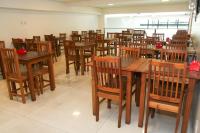 uma sala de jantar cheia de mesas e cadeiras de madeira em Logic Hotel Volta Redonda em Volta Redonda
