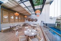 um restaurante com mesas e cadeiras na varanda em Truntum Cihampelas em Bandung
