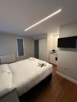 Un dormitorio con una cama grande y una cocina. en Buckingham Annexe, en High Wycombe