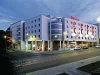 Un gran edificio blanco en una calle de la ciudad por la noche. en Ibis Szczecin Centrum, en Szczecin