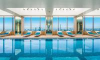 a hotel pool with chairs and a view of the city at The Prince Gallery Tokyo Kioicho, a Luxury Collection Hotel in Tokyo