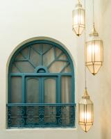 Una ventana arqueada con una puerta azul y dos luces. en Riad Tassili, en Chefchaouen