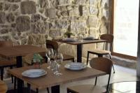 un comedor con 2 mesas y sillas con copas de vino en Hostal Boutique Restaurante El Algars, en Caseras