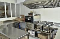 Una cocina con encimeras de acero inoxidable y una estufa. en Hostal Boutique Restaurante El Algars, en Caseras
