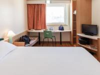 Una habitación de hotel con una cama, un escritorio y una ventana. en Ibis Murcia, en Murcia