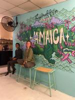 two people sitting on a bench in front of a mural at Ragamuffin Hostel in Kingston