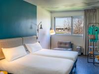 Una habitación de hotel con dos camas y una ventana. en Ibis Barcelona Aeropuerto Viladecans, en Viladecans