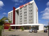 Un hotel con coches aparcados en un estacionamiento. en ibis Betim, en Betim