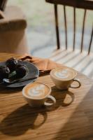 twee kopjes koffie en een bordje muffins op tafel bij The Kul Kul Farm in Bringkit