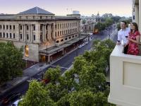 dos mujeres de pie en la cornisa de un edificio en Grosvenor Hotel Adelaide by Accor, en Adelaida