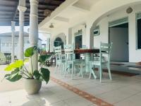 a dining room with white chairs and a table and a plant at Nice Days Resort Unawatuna in Unawatuna
