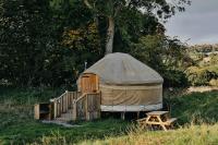 una yurta con una escalera de madera y un banco de madera en Rock Farm Slane - Glamping, en Slane