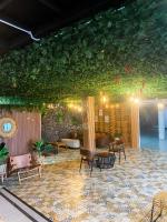 Una habitación con sillas y una pared con plantas. en Baith Glamping, en Cihideung