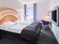 Una habitación de hotel con una cama, un escritorio y un televisor. en B&amp;B Hotel Offenbach-Kaiserlei, en Offenbach