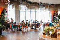 芽庄Coastal Charm Panorama Bayview的一群人坐在餐厅的桌子旁