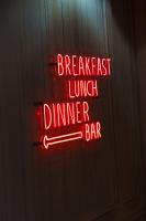 een neonbord met de tekst 'de gekste lunch- en dinerbar' bij M Social Hotel Paris Opera in Parijs
