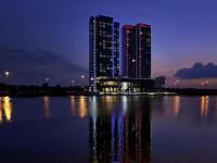 Un gran edificio con luces en el agua por la noche. en Ibis Abu Dhabi Gate, en Abu Dabi