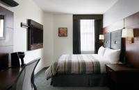 ヒューストンにあるClub Quarters Hotel Downtown, Houstonのベッドとテレビがあるホテルの部屋