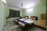Dos camas en una habitación con paredes verdes. en SPOT ON Hotel Hilltop, en Vadodara
