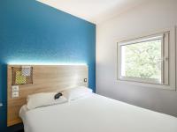Un dormitorio con una cama blanca y una ventana. en hotelF1 Lyon Saint Priest, en Saint-Priest