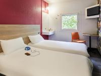 a hotel room with two beds and a sink at hotelF1 Saint Etienne in Saint-Étienne