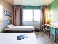 Una habitación de hotel con dos camas y un escritorio. en ibis budget Angoulême Nord, en Champniers