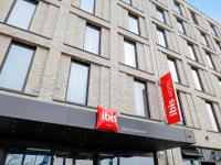 un edificio con dos letreros rojos delante de él en Ibis Berlin Hauptbahnhof, en Berlín