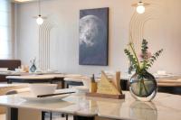 Un comedor con mesas y un jarrón con flores sobre una mesa. en Atour S Hotel Ningbo Heyi Avenue, en Ningbo
