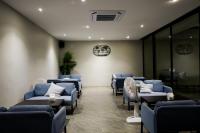 een wachtkamer van een ziekenhuis met blauwe stoelen en een ventilator bij Sek Sky Villa&Cafe in Ban Kham Kom