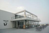 een gebouw met tafels en stoelen ervoor bij Sek Sky Villa&Cafe in Ban Kham Kom