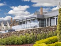 un edificio de oficinas con un muro de contención de piedra en Mercure Goulburn, en Goulburn