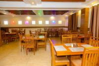 Un comedor con mesas y sillas de madera. en Hotel Ultra International, en Bhairāhawā