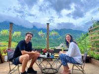 Un uomo e una donna seduti a un tavolo su un patio di The Chill Garden Sapa a Sa Pa