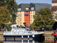 a boat docked in the water in front of a building at ibis budget Auxerre Centre in Auxerre