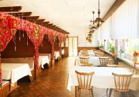 OberzentにあるZum Goldenen Löwenのテーブルと椅子、赤いカーテンが備わるレストラン