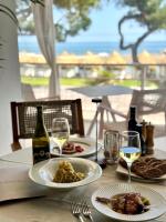 ein Tisch mit Tellern mit Essen und Gläsern Wein in der Unterkunft DB Villas Le Ville del Lido Resort in Lido di Venezia