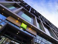 un edificio con una señal verde en el costado. en ibis Styles Pforzheim, en Pforzheim
