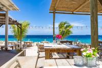 a table on the beach with a view of the ocean at BijBlauw in Willemstad