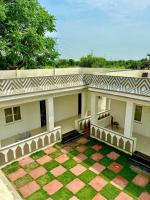 布什格尔Radha Kunj Resort Pushkar的庭院中带门廊和椅子的房子