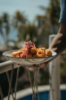 una persona tiene in mano un piatto di cibo di Cadejo Brewing Company El Sunzal a Tamanique