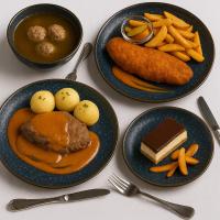 una mesa con platos de comida y patatas fritas en Luxury Hotel Siófok, en Siófok