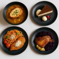 Cuatro platos negros de comida sobre una mesa en Luxury Hotel Siófok, en Siófok