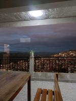 Un balcón con una mesa y vista a una ciudad. en Fanai Inn, en Āīzawl