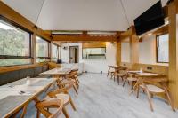 een eetkamer met houten tafels en stoelen bij Amanara Villa Pangandaran in Pangandaran