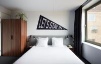Un dormitorio con una cama y un cartel que dice &quot;quedémonos en casa&quot;. en The Social Hub Groningen, en Groninga