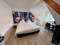 a bedroom with a bed and a desk and a painting at Hotel Bitzer Backnang Zentrum 24h CHECK IN FRÜHSTÜCKSBUFFET TÄGLICH OPTIONAL VOR ORT BUCHBAR HIGHSPEED WIFI GRATIS PARKPLÄTZE ALTSTADT 300m BAHNOF 500m in Backnang