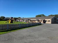 un edificio con recinto accanto a un parco giochi di Bayview at Pengarreg a Llanrhystyd