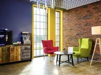 a room with three chairs and a table and a brick wall at ibis Styles Arad in Arad